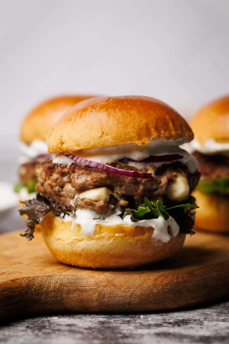 A lamb slider on a wooden board.