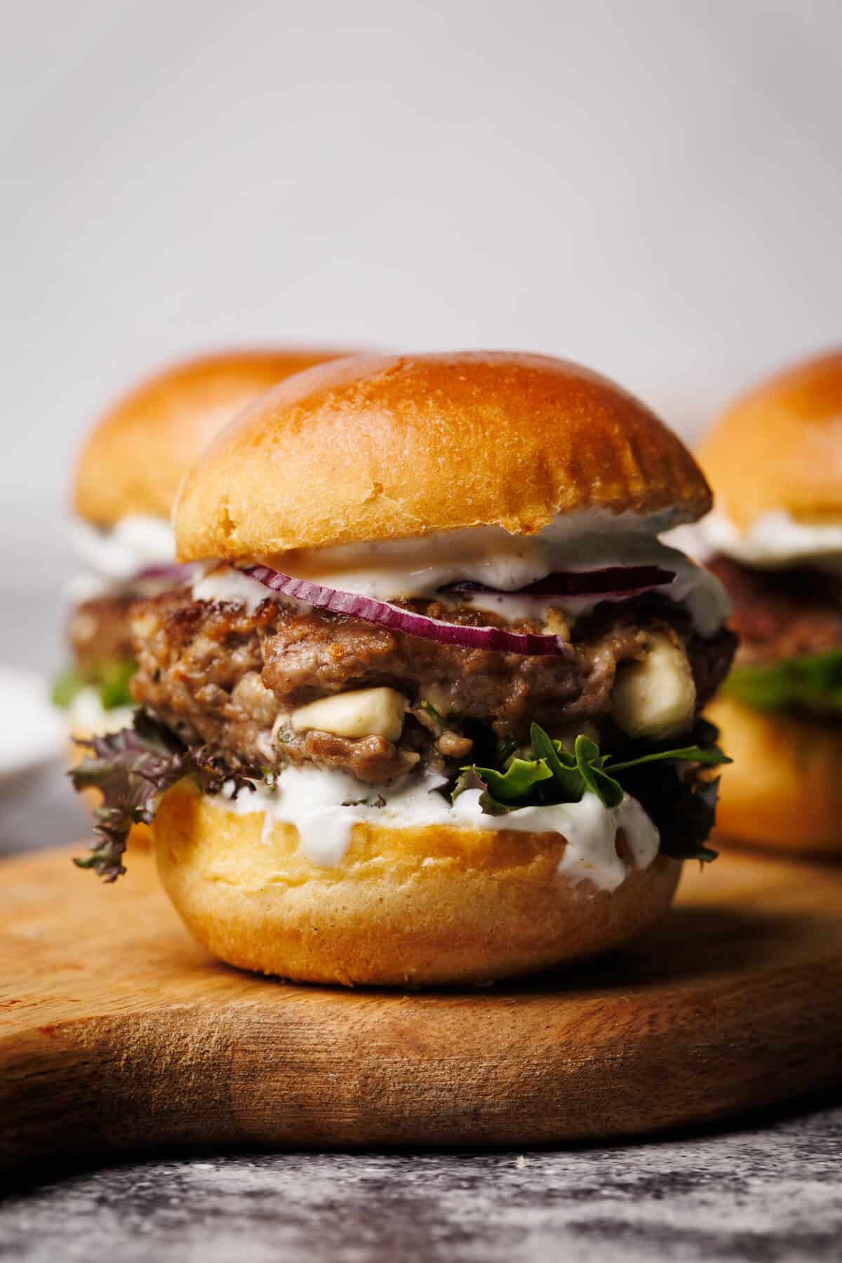 A lamb slider on a wooden board.