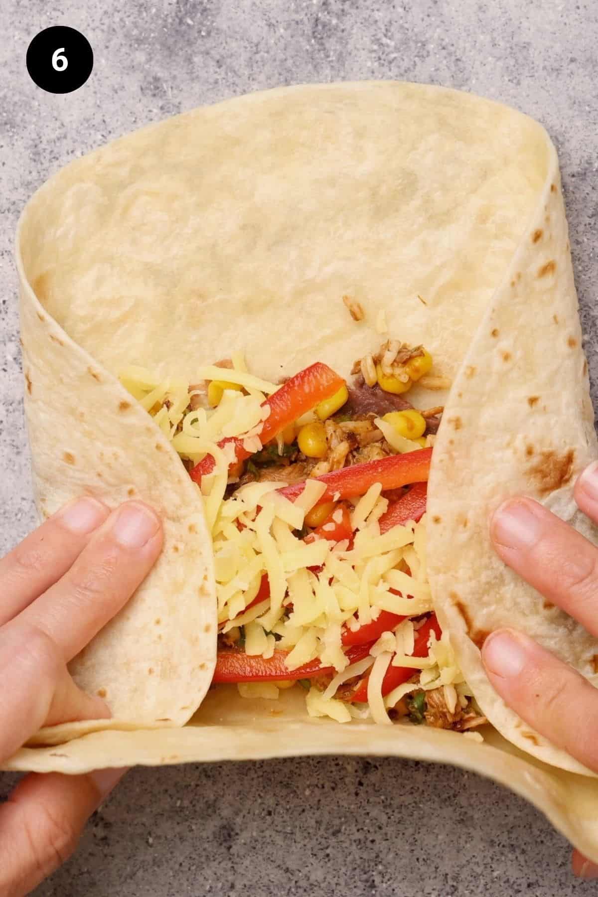 The burrito is being rolled up.
