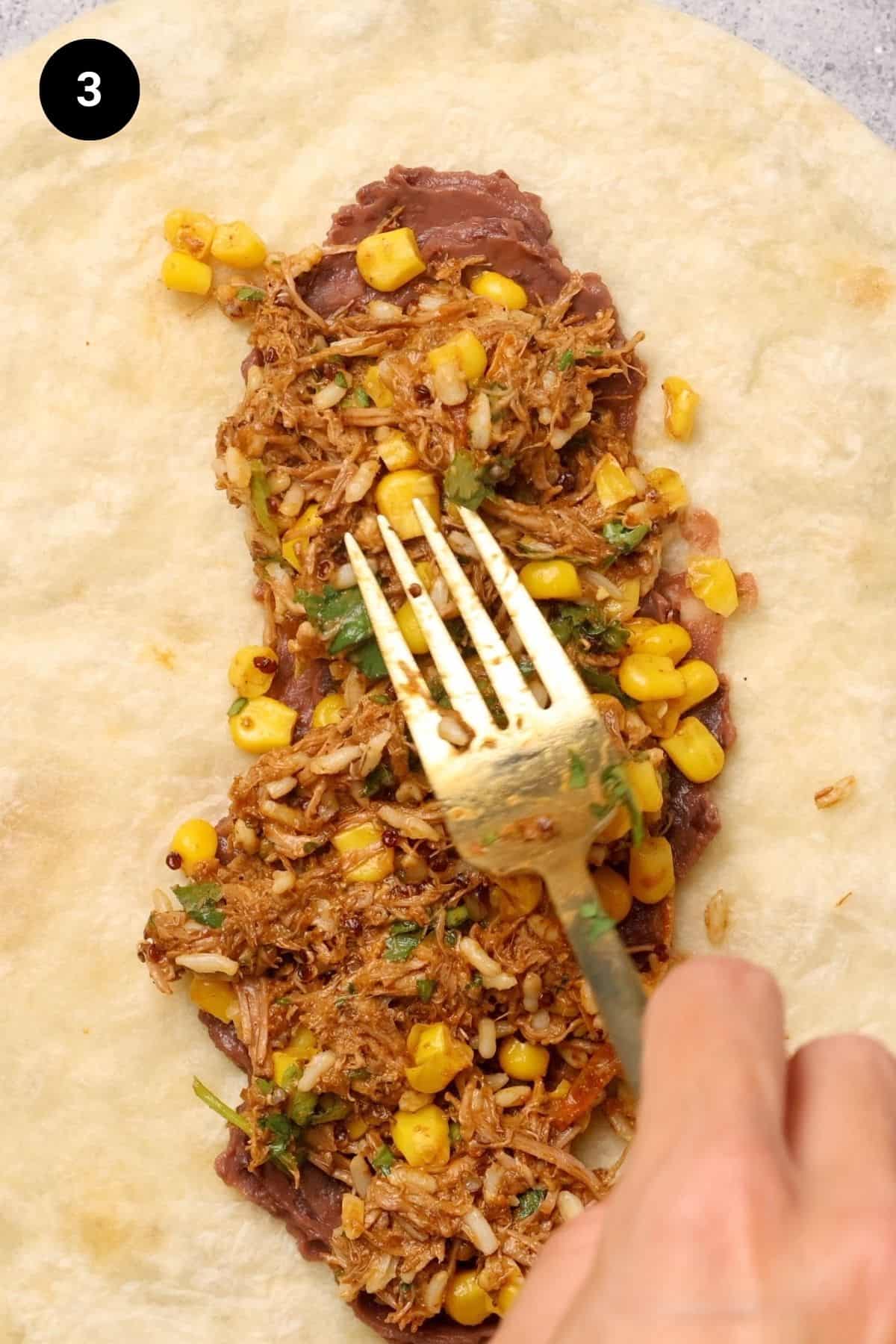 Birria filling added to burrito.
