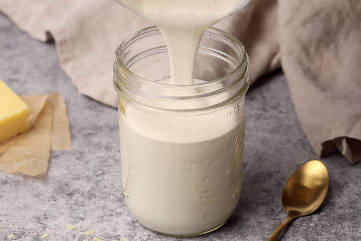 Cottage cheese pasta sauce being poured into a mason jar.