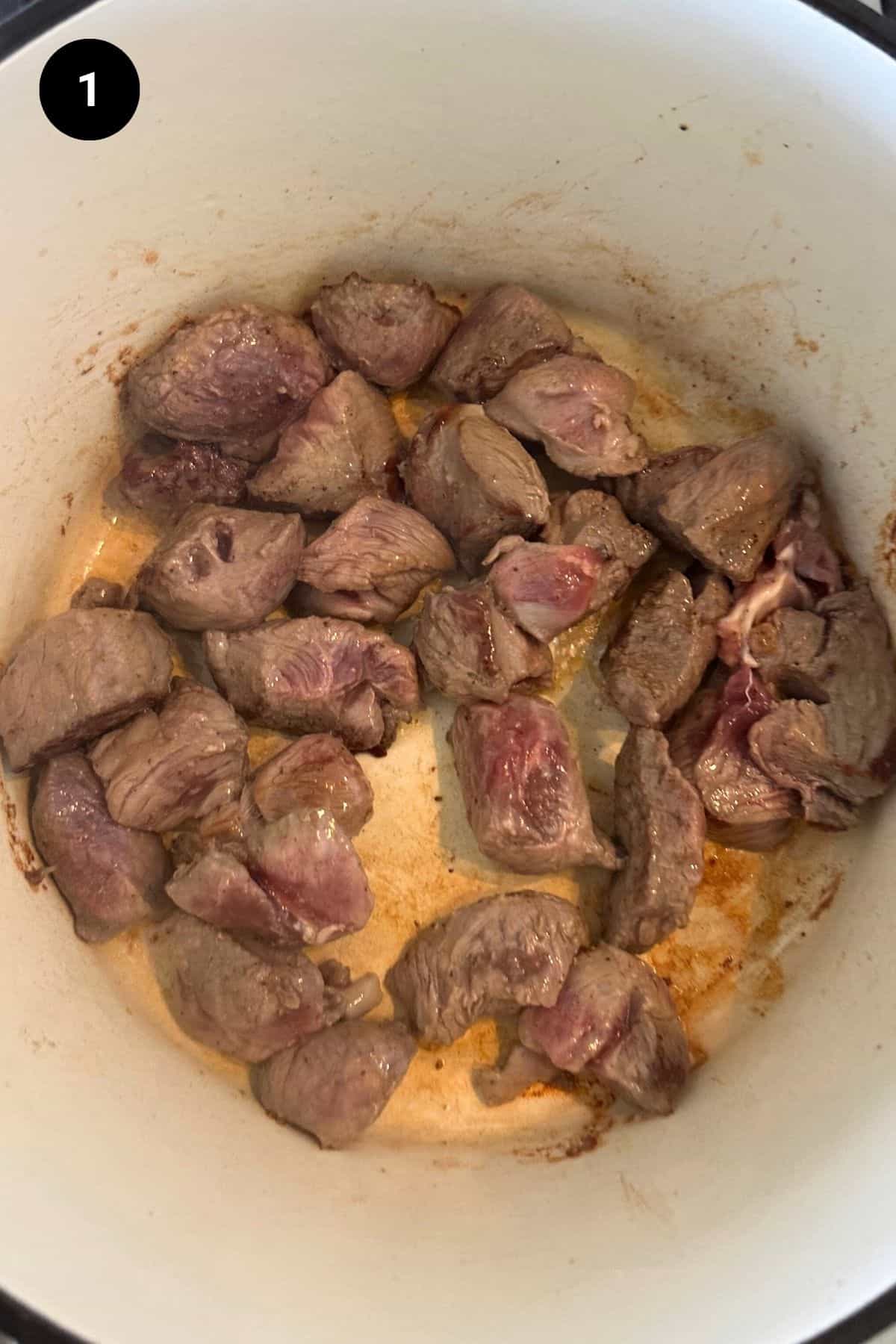 Searing lamb in a Dutch oven.