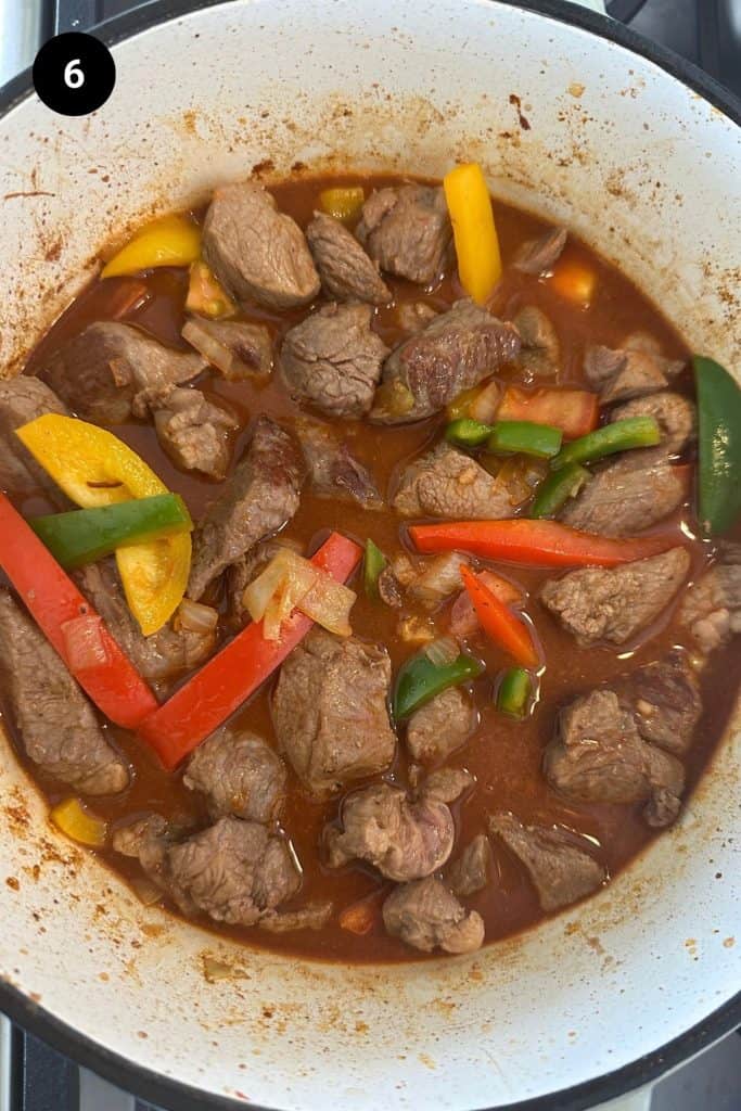 Goulash ready to be slow-cooked in a Dutch oven.
