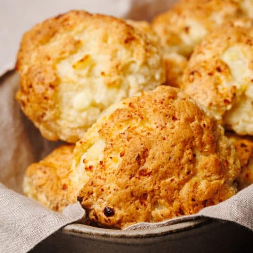 Cottage cheese biscuits in a linen towel in a baking dish.