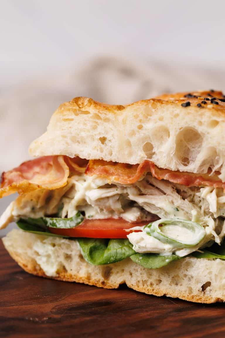 Chicken bacon ranch sandwich on a wooden board.