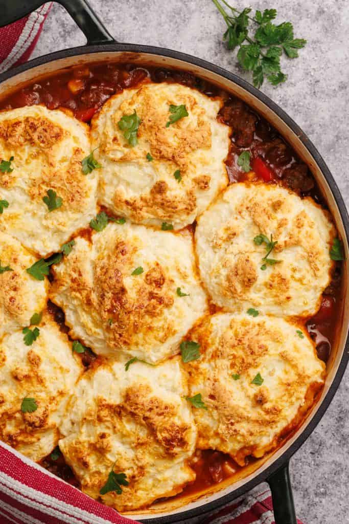 Cowboy casserole with biscuits in a Dutch oven.