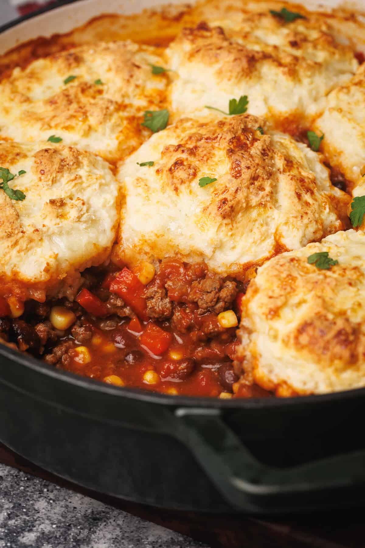 Cowboy casserole in a Dutch oven with a scoop taken out.