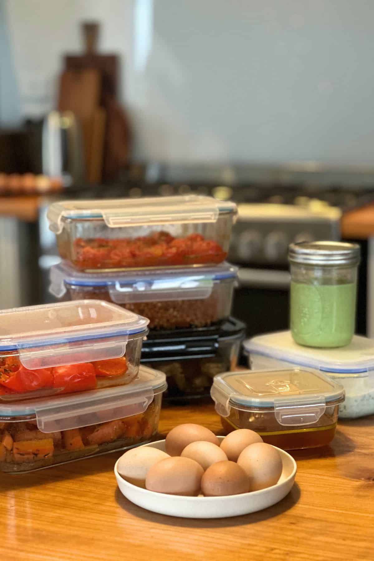 A stack of food containers on a wooden bench.